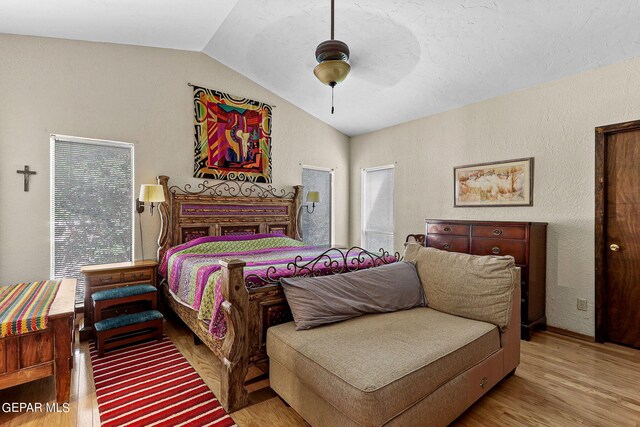 bedroom with ceiling fan, light hardwood / wood-style floors, lofted ceiling, and multiple windows