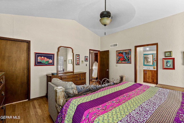 bedroom with baseboards, visible vents, lofted ceiling, ceiling fan, and wood finished floors