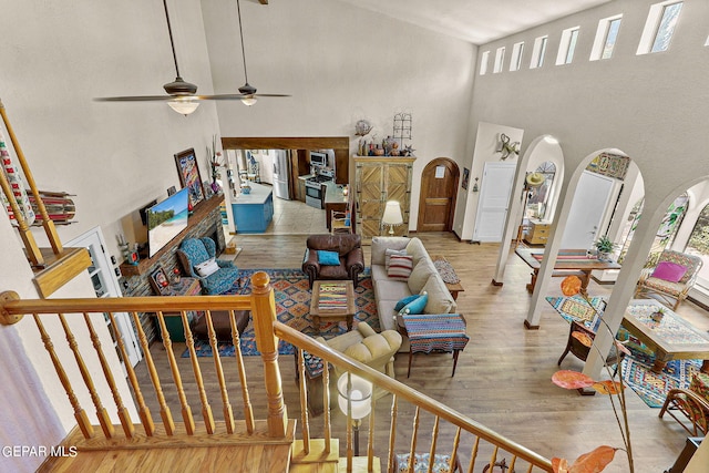 living room featuring stairs, a high ceiling, and wood finished floors