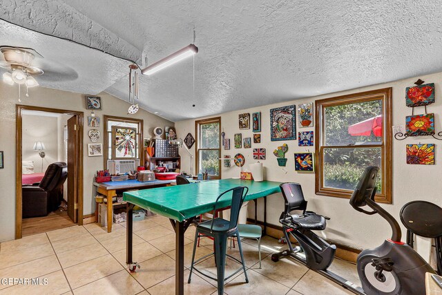 playroom featuring a textured ceiling, vaulted ceiling, ceiling fan, and light tile patterned flooring