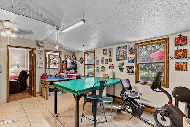 rec room featuring baseboards, vaulted ceiling, a textured ceiling, and light tile patterned flooring