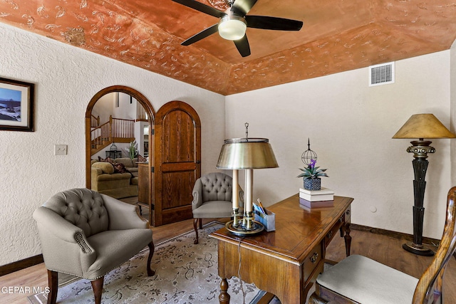 630 Gary Ln, El Paso, TX 79922 - office area featuring wood finished floors, ceiling fan, a textured wall, arched walkways, and baseboards