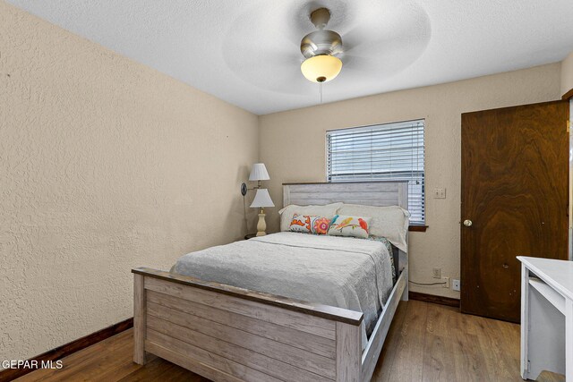 630 Gary Ln, El Paso, TX 79922 - bedroom featuring a textured wall, wood finished floors, baseboards, and a ceiling fan