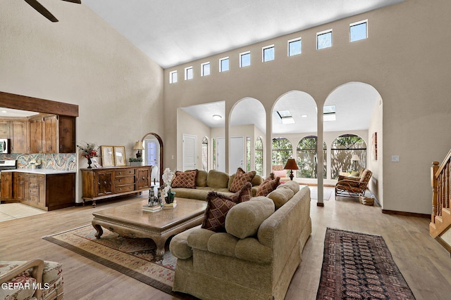 630 Gary Ln, El Paso, TX 79922 - living area with a towering ceiling, light wood-type flooring, arched walkways, stairway, and baseboards