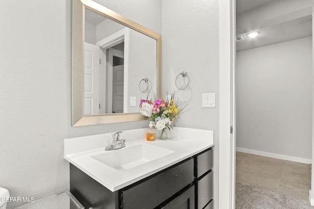 bathroom featuring toilet, tile patterned flooring, and vanity