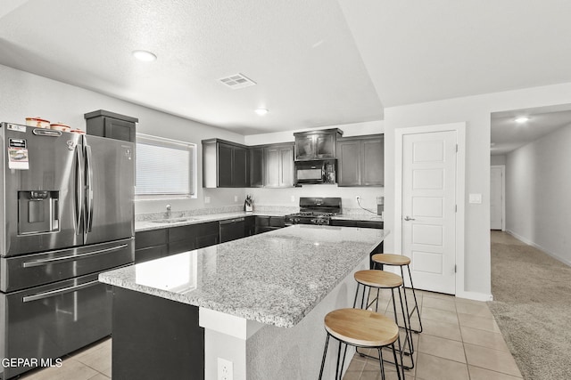 kitchen with a center island, sink, light stone counters, light carpet, and black appliances