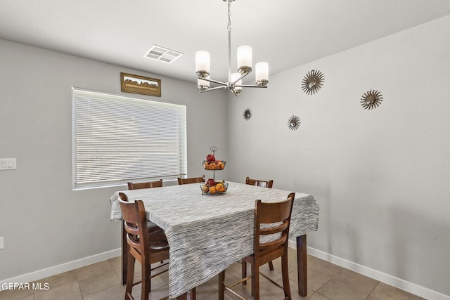 dining space with tile patterned flooring and a chandelier