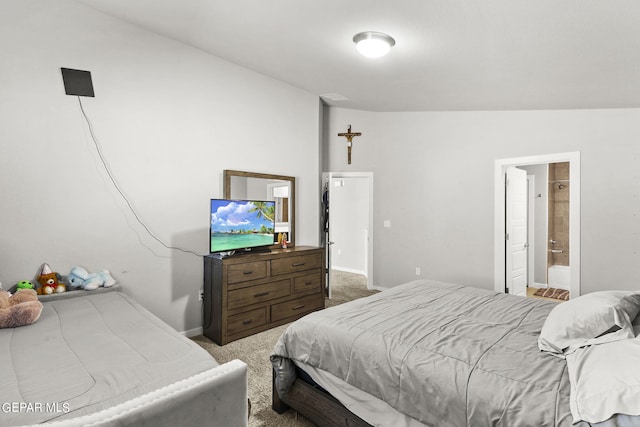 bedroom featuring carpet flooring, ensuite bathroom, and lofted ceiling