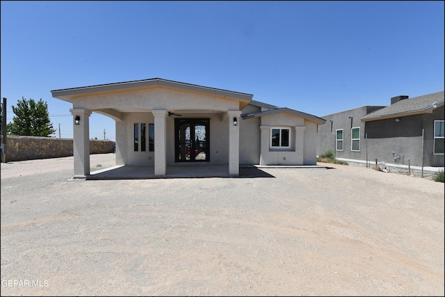 view of front of property featuring a patio, fence, and stucco siding