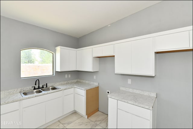 kitchen featuring white cabinets, sink, and light tile patterned floors