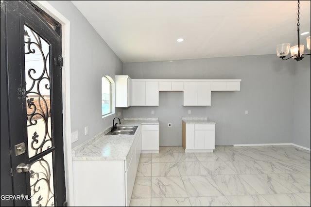 kitchen with white cabinetry, an inviting chandelier, sink, lofted ceiling, and light tile patterned flooring