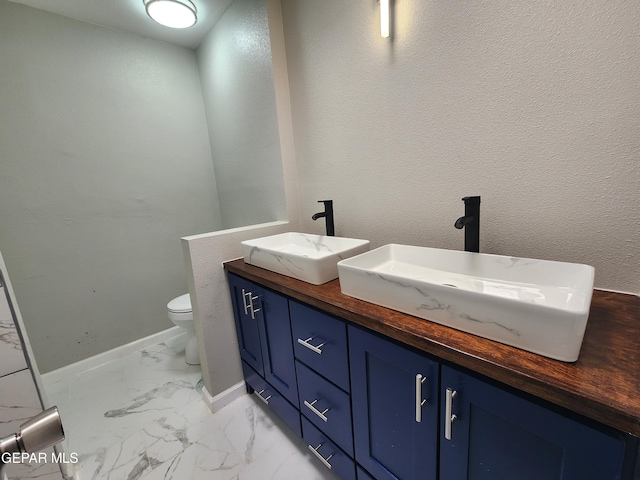 bathroom with toilet, vanity, and tile patterned floors