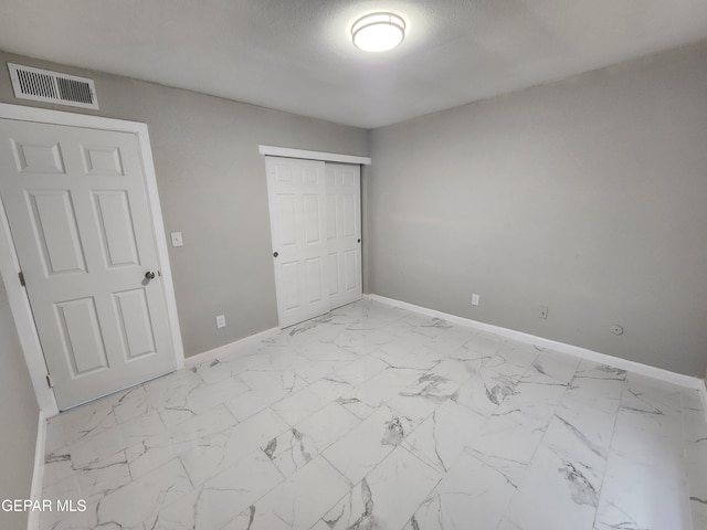 unfurnished bedroom featuring a closet and light tile patterned floors