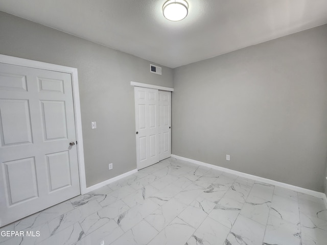 unfurnished bedroom featuring light tile patterned flooring and a closet