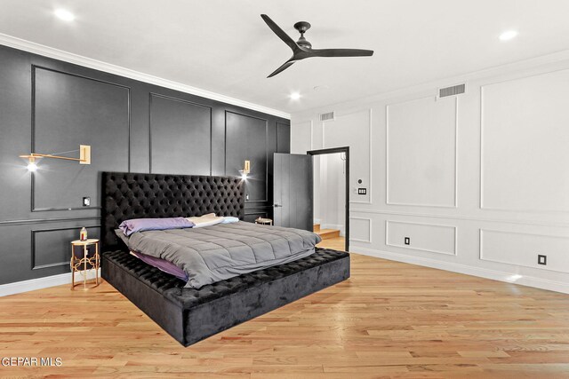 bedroom featuring crown molding, light hardwood / wood-style floors, and ceiling fan