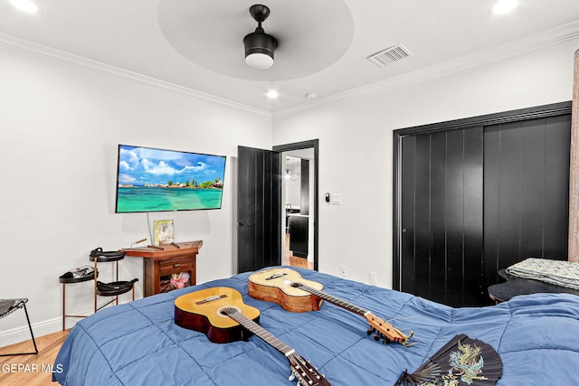 bedroom featuring ornamental molding, ceiling fan, and hardwood / wood-style floors