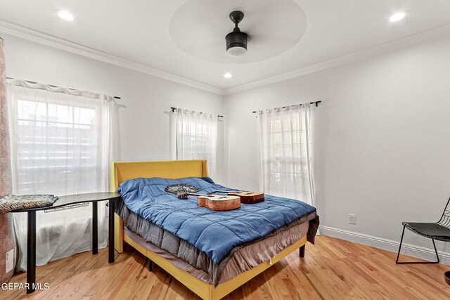 bedroom featuring ceiling fan, light wood-type flooring, and crown molding