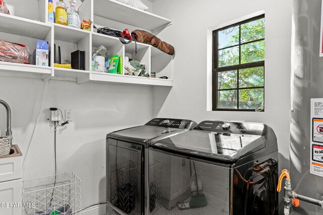 washroom featuring gas water heater and washing machine and clothes dryer