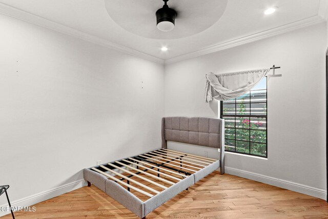 bedroom featuring wood-type flooring, crown molding, and ceiling fan