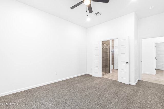 unfurnished bedroom featuring ceiling fan, light colored carpet, and ensuite bathroom