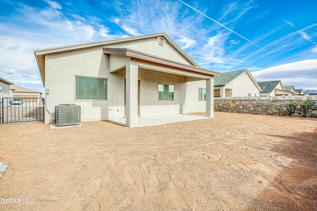 rear view of house with central AC unit and a patio area