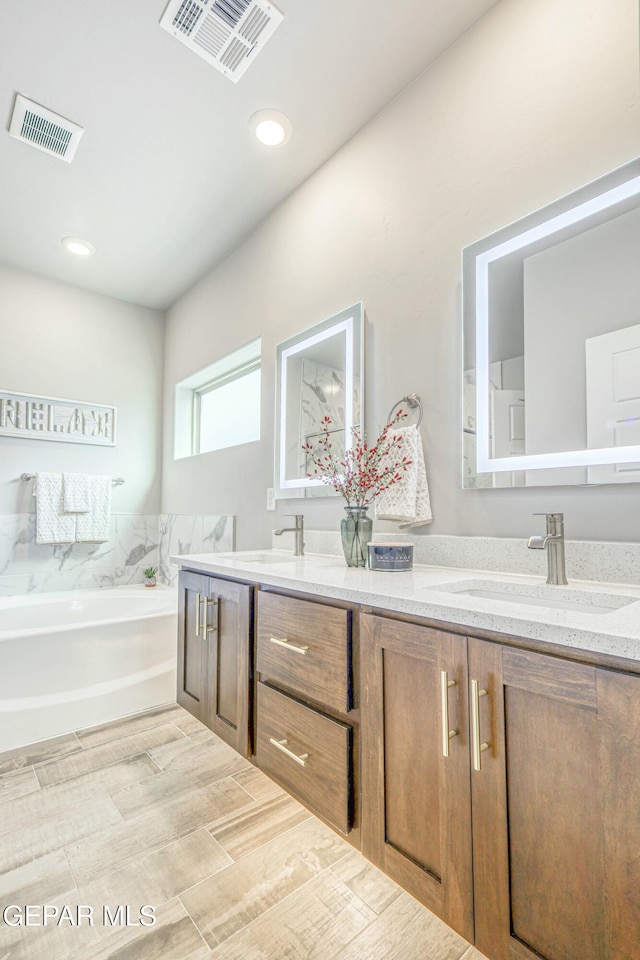 bathroom featuring a washtub, wood-type flooring, and vanity