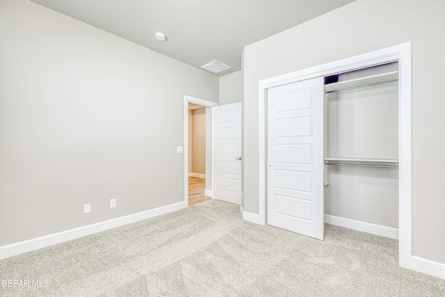 unfurnished bedroom featuring light colored carpet and a closet