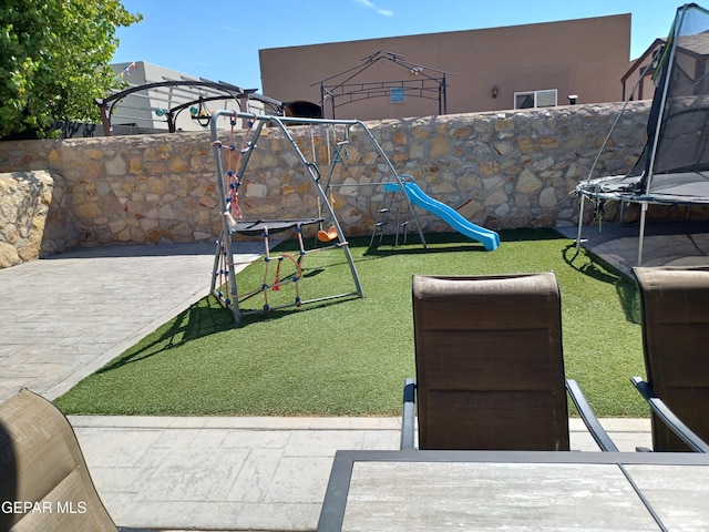 view of yard featuring a playground, a patio area, and a trampoline