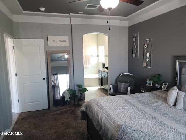 bedroom with light carpet, ensuite bathroom, and ceiling fan