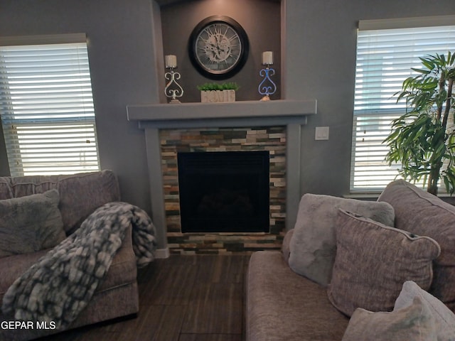 living room featuring plenty of natural light, hardwood / wood-style floors, and a stone fireplace