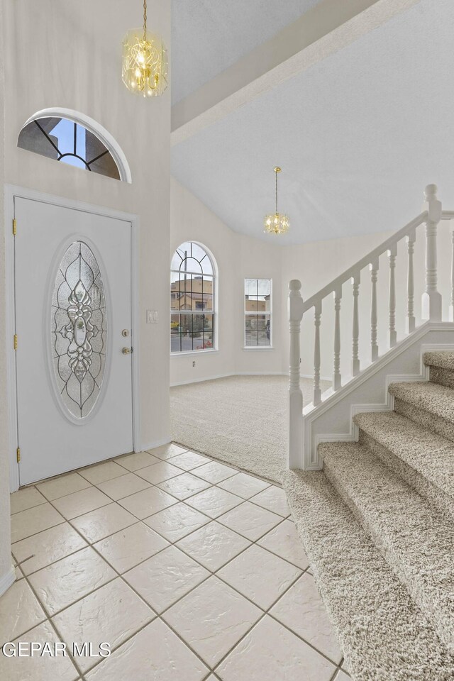 entrance foyer featuring beamed ceiling, a notable chandelier, and carpet floors