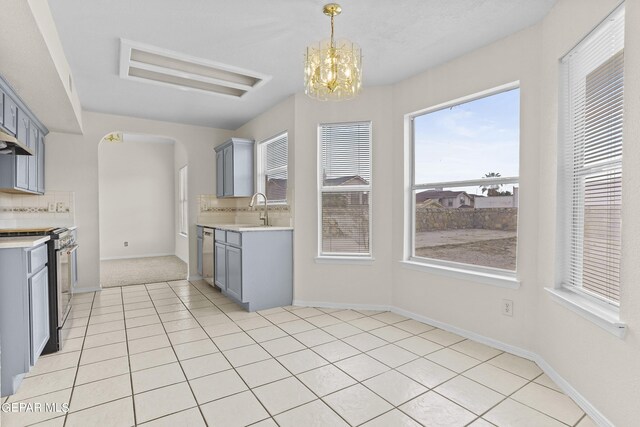 kitchen featuring pendant lighting, an inviting chandelier, a wealth of natural light, and stainless steel appliances