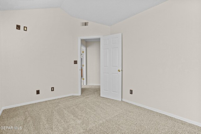 empty room featuring light carpet and lofted ceiling