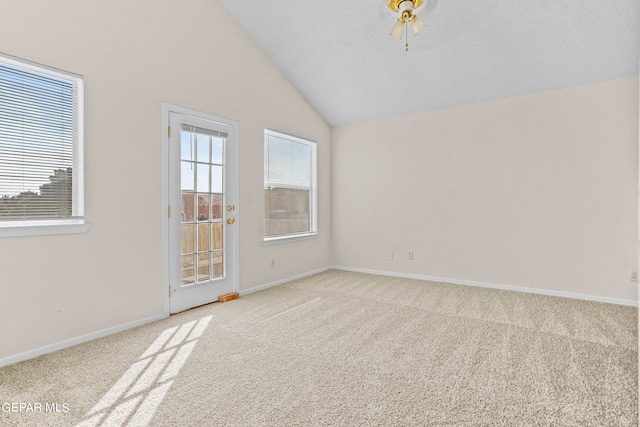 carpeted spare room featuring vaulted ceiling and ceiling fan