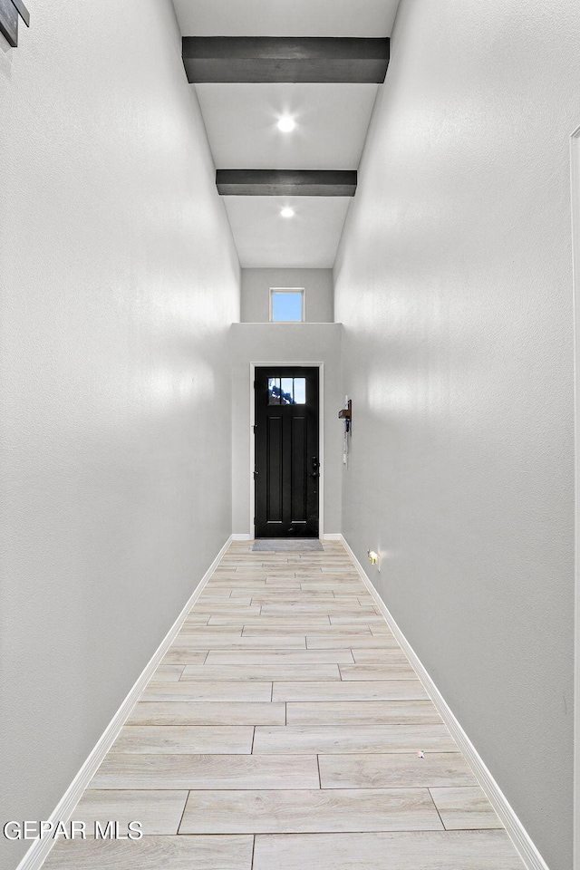 entryway with beam ceiling and light hardwood / wood-style flooring