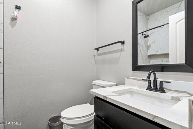 bathroom with a shower, toilet, and vanity