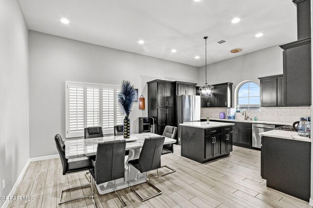 dining room with light wood-type flooring and an inviting chandelier