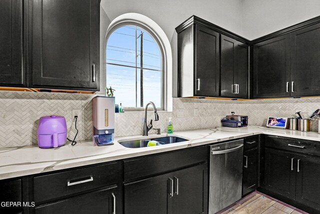 kitchen featuring dishwasher, decorative backsplash, light hardwood / wood-style floors, and sink