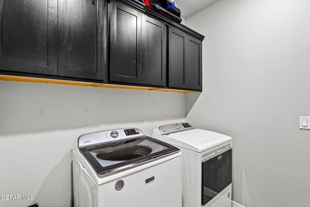 washroom featuring independent washer and dryer and cabinets