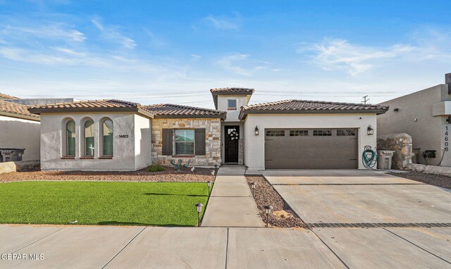 mediterranean / spanish home with a garage and a front lawn