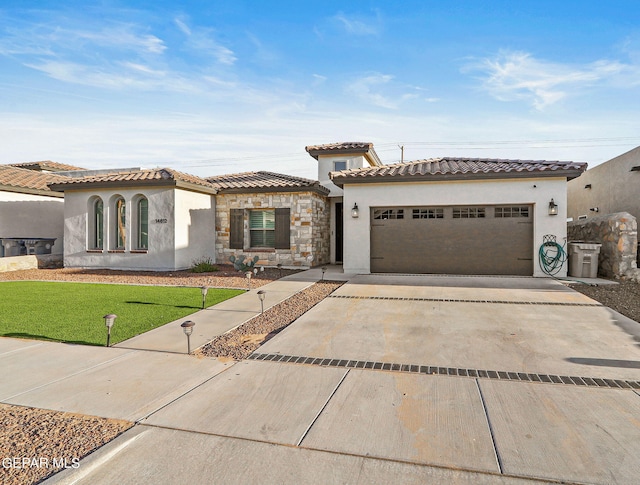 mediterranean / spanish house with a garage and a front yard