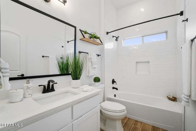 bathroom with shower / bathtub combination, wood finish floors, vanity, and toilet