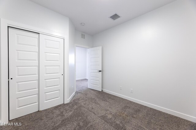 unfurnished bedroom with a closet and carpet floors