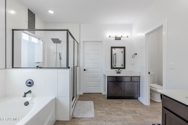 full bathroom featuring plus walk in shower, wood-type flooring, toilet, and vanity