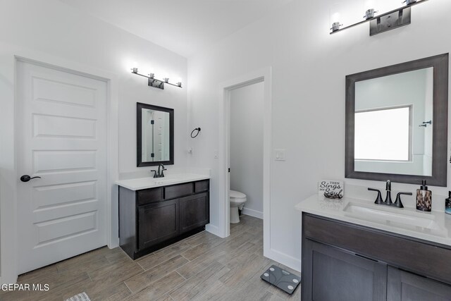 bathroom with hardwood / wood-style floors, toilet, and vanity