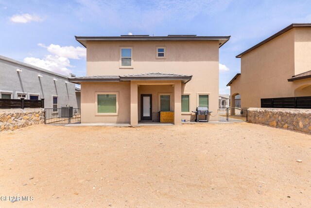 rear view of house with cooling unit and a patio area