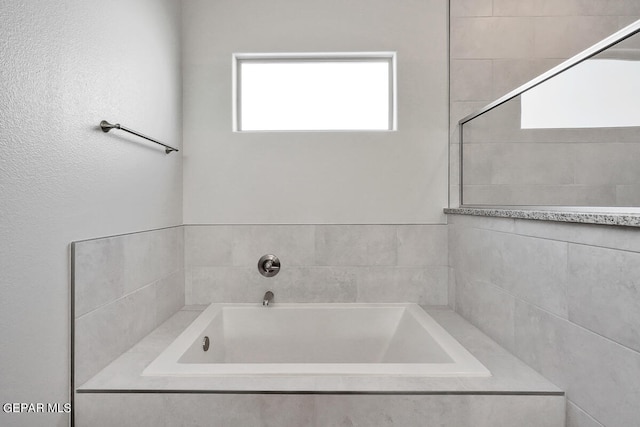 bathroom with a relaxing tiled tub