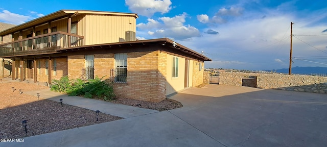 view of side of property with a balcony and brick siding