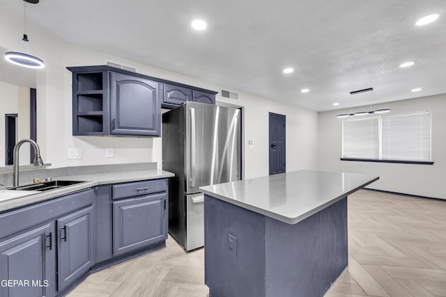 kitchen with stainless steel fridge, a center island, light parquet floors, and pendant lighting