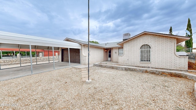 view of front facade with brick siding, an attached garage, fence, and central air condition unit